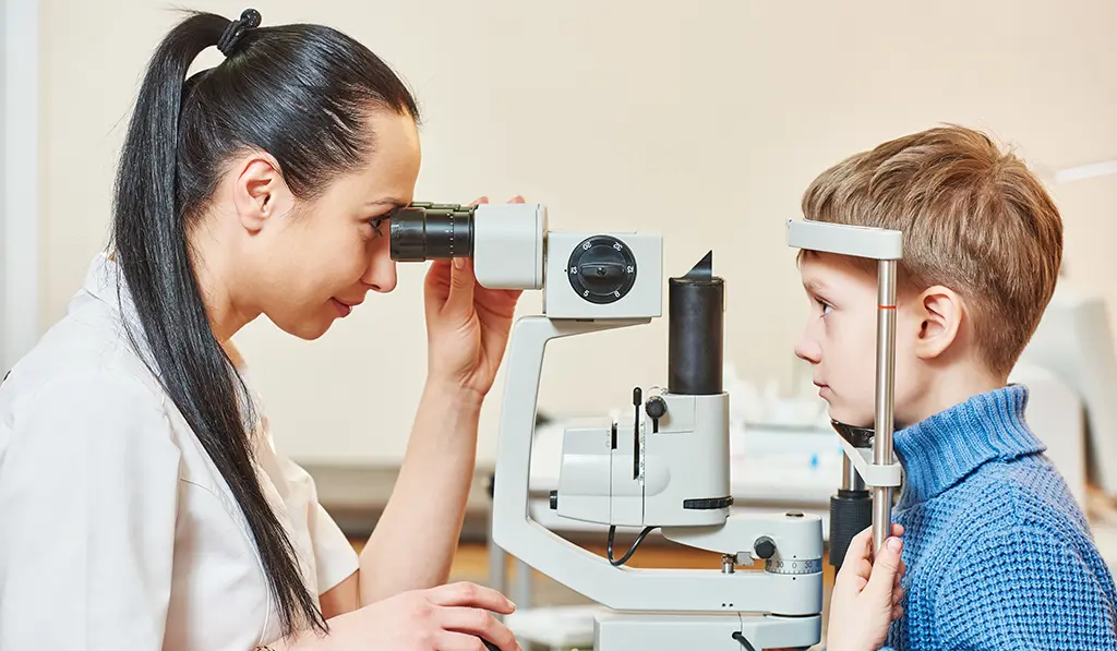 Eye doctor using machine to look at child's eyes
